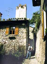 Haus aus Bruchsteinen im alten Ortskern Malcesines. Im Hintergrund der Turm der Scaliger-Festung