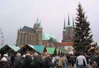 Holzbuden und geschmückte Tanne auf dem Weihnachtsmarkt unterhalb von Dom und Servikirche